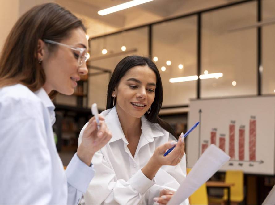 Two marketing professionals discussing a customer success strategy during a meeting in a modern office.