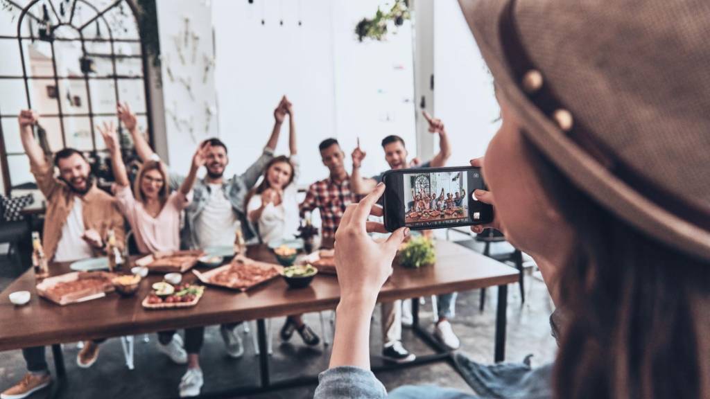 Woman capturing a group photo to illustrate influencer collaboration and community-building content.