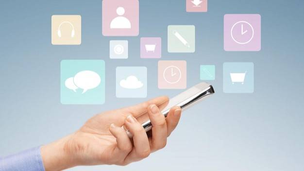 Hand holding a smartphone with floating icons representing various communication tools for customer engagement.