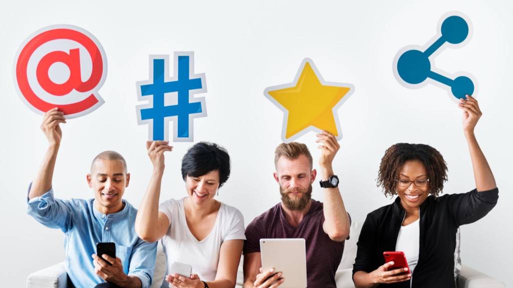 Group of people holding social media icons to boost visibility using growth hacks for content marketing.
