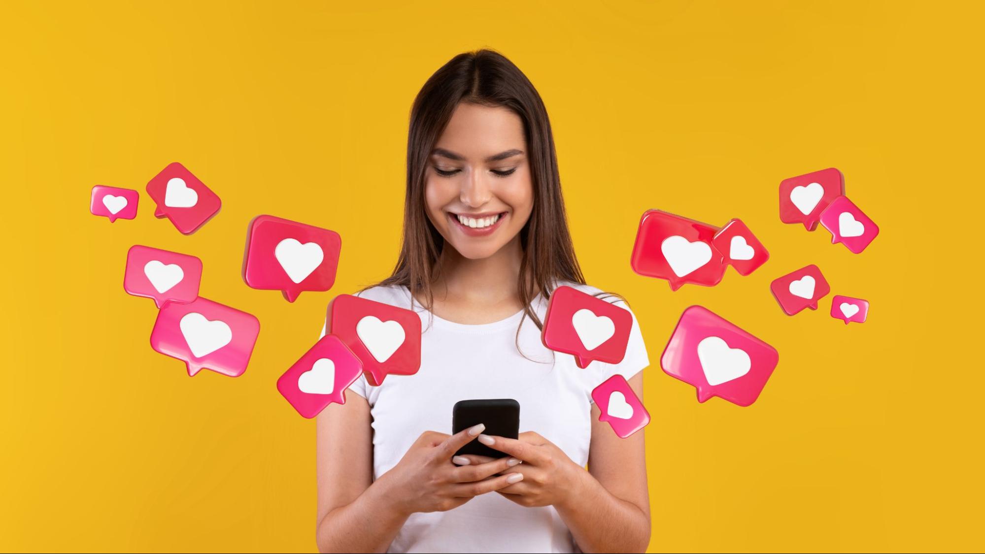 Smiling woman looking at her phone while heart-shaped Instagram likes float around her, representing content engagement success.