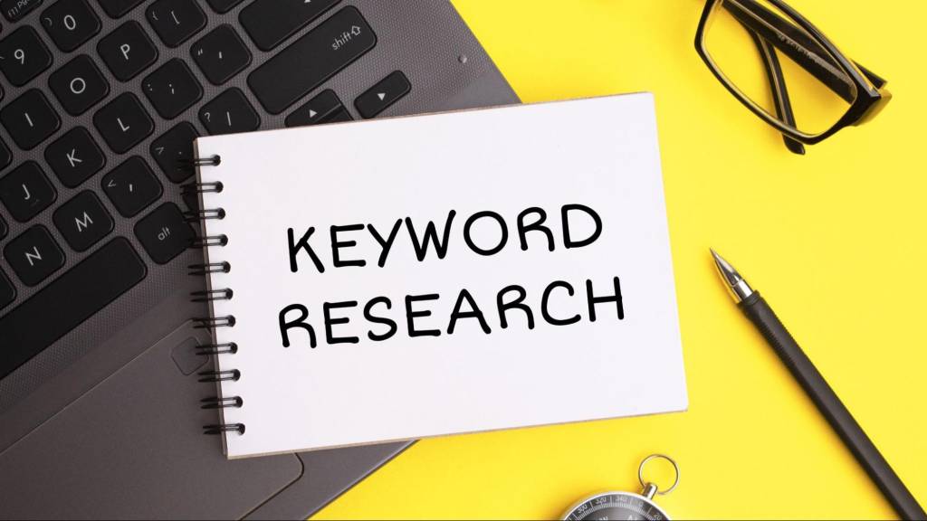 Notebook with the words 'Keyword Research' placed on a laptop keyboard—representing strategic planning for Instagram SEO