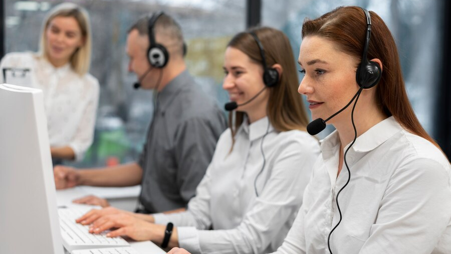 Contact center workers using specialized software to manage customer interactions and enhance satisfaction, illustrating effective customer service solutions.