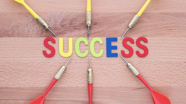 A wooden board with colorful darts targeting the word "success," symbolizing focus and strategy in marketing trends for 2025.