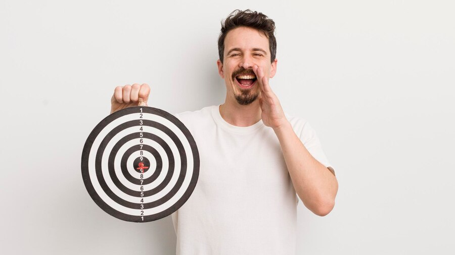 Man smiling while holding a bullseye target, highlighting the importance of precise audience targeting in PPC strategy.