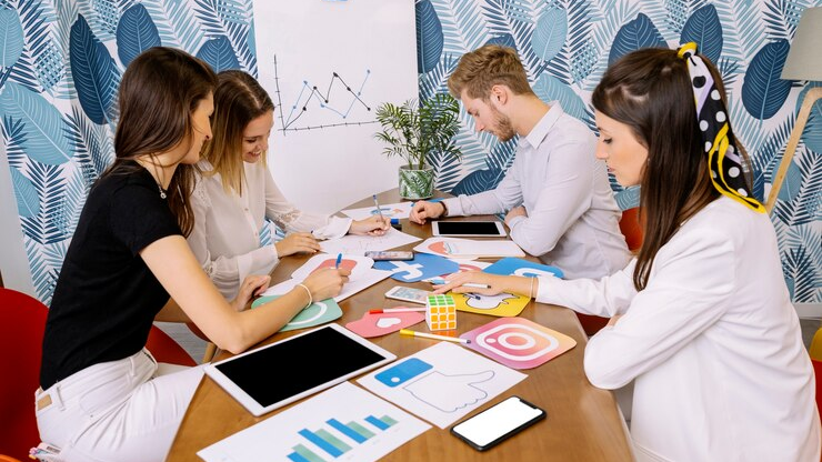 A group of people in an office working on business objectives for a Quarterly Strategy, analyzing a graph from a previous report.