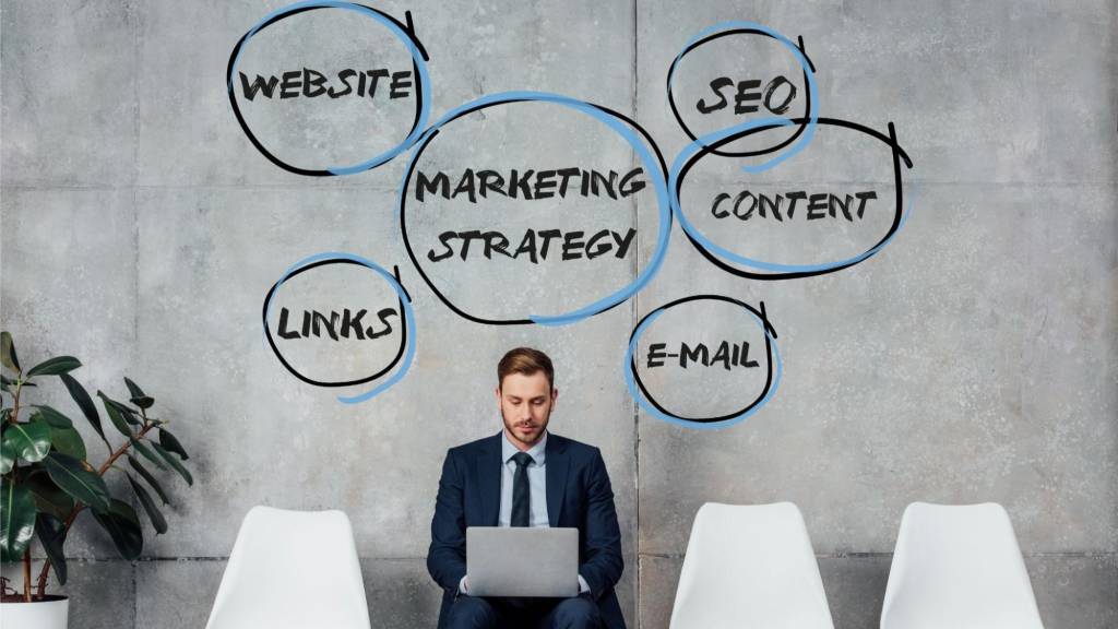 Business professional working on laptop with marketing strategy keywords like website, SEO, links, email, and content for a unified ad strategy.