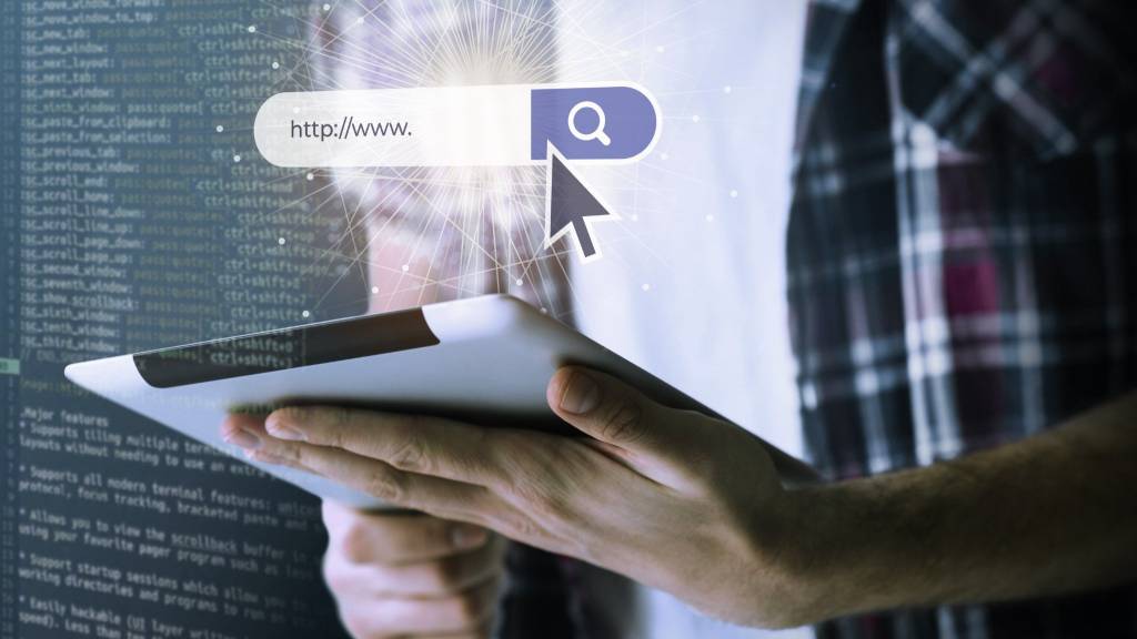 Person using tablet to browse the web with search bar graphic representing conversational AI and modern SEO optimization.