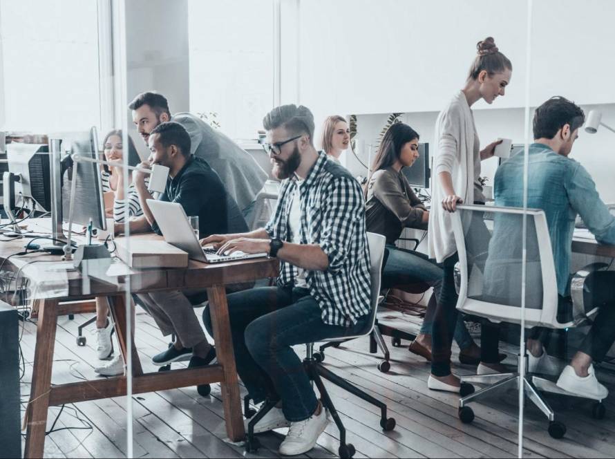 A team of digital marketing professionals working collaboratively in a modern office, illustrating the specialized SEO experts hired by tech giants and agencies.