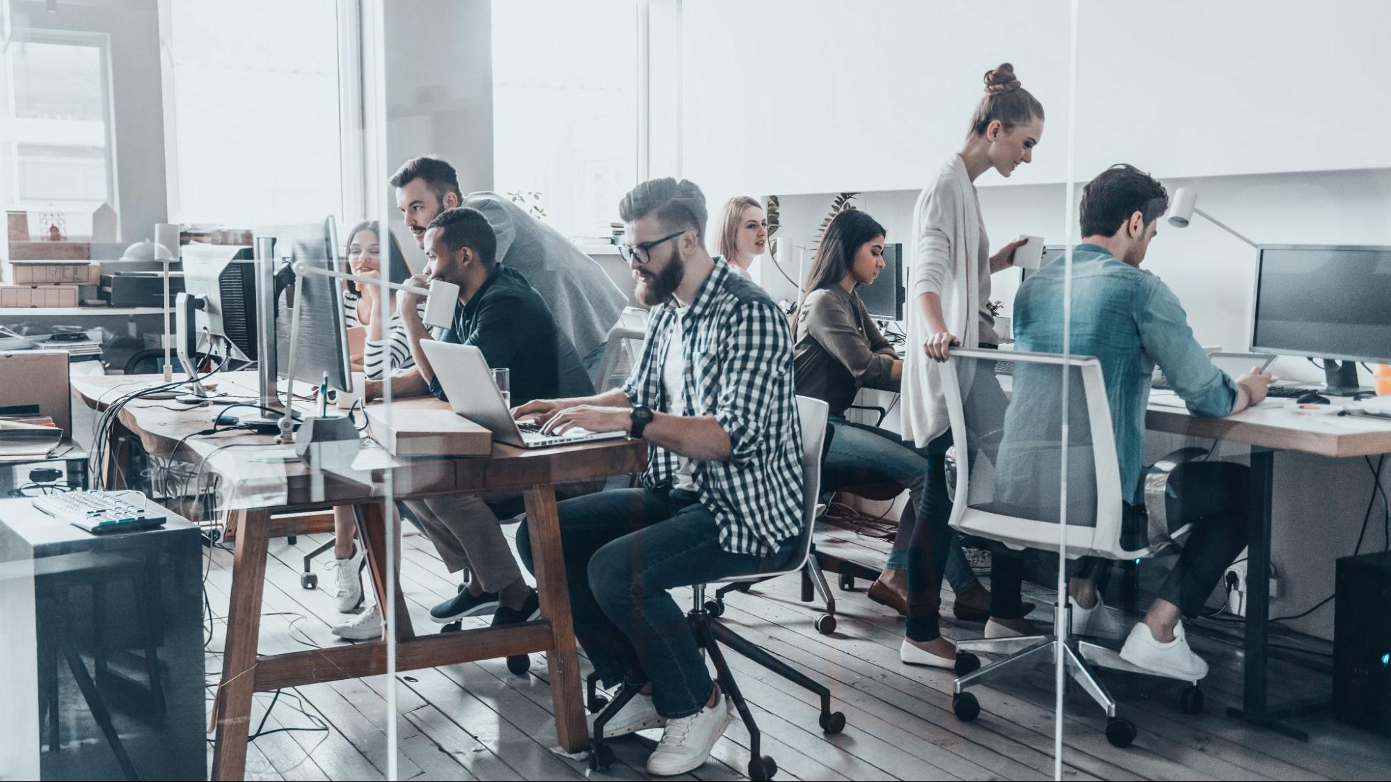 A team of digital marketing professionals working collaboratively in a modern office, illustrating the specialized SEO experts hired by tech giants and agencies.