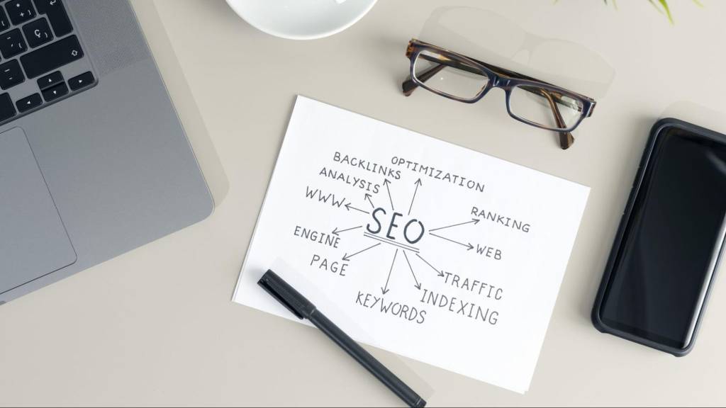 A desk featuring a laptop and a hand-drawn SEO mind map, representing the technical AI search optimization strategy used for Florida businesses.