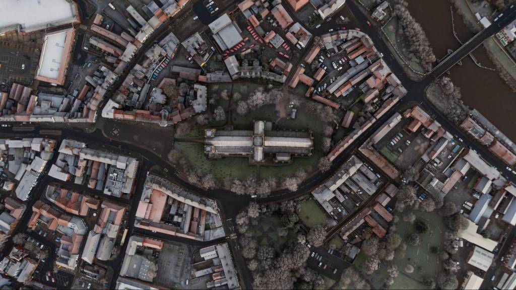 A high-angle aerial view of a city center and a cathedral, illustrating the photorealistic 3D data used in the Google Maps Immersive View update to help customers discover Florida businesses.