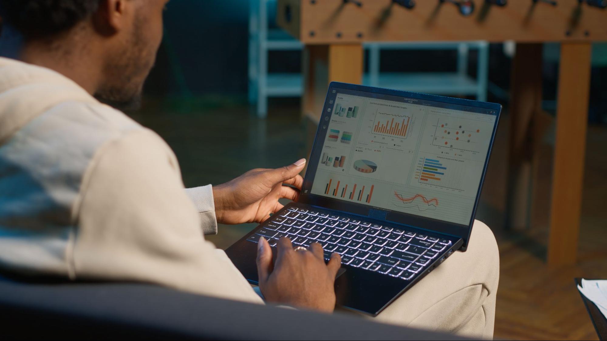 A digital marketing professional analyzing a complex data dashboard on a laptop, representing the process of ChatGPT traffic analysis and evaluating AI interaction metrics.