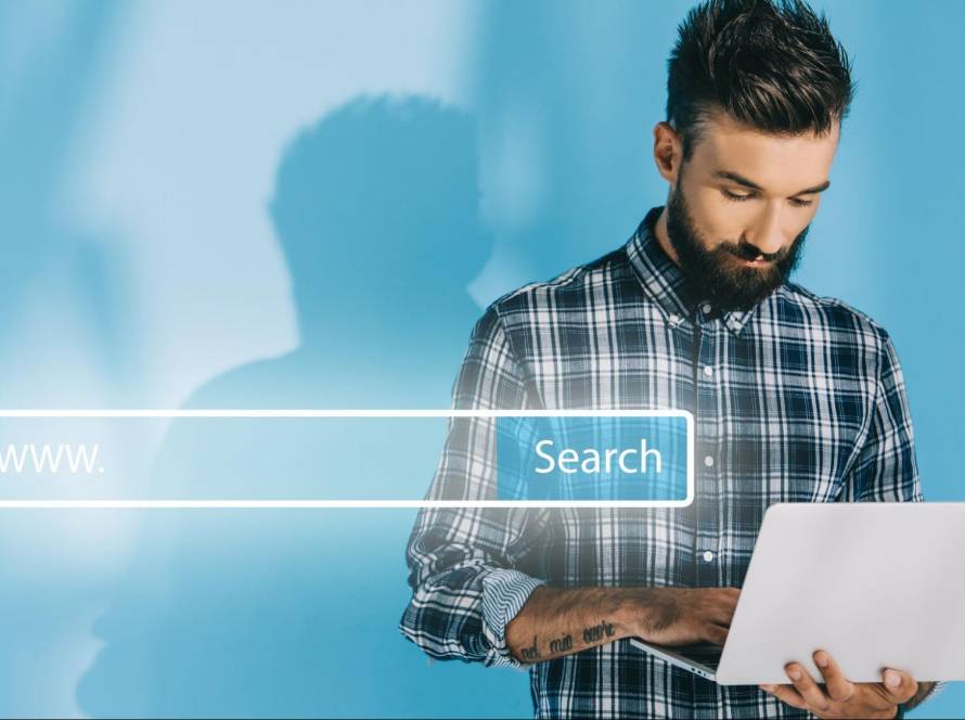 A man typing on a laptop next to a glowing web search bar graphic, representing the process of finding your perfect AI assistant.